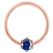 14k rose gold captive bead ring with blue CZ prong set, warm rose tone contrasts blue stone