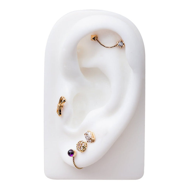 14k yellow gold pyramid stud in helix as part of curated ear party with mixed gold cartilage jewelry