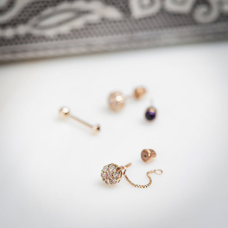 Rose gold box chain connector styled with CZ cluster stud earring, flat lay with mixed jewelry