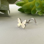 14K white gold butterfly nose screw with opal-effect wings, styled beside succulents