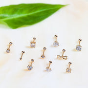 Assorted 14k gold cartilage studs in various styles showing size range, including 5mm diamond prong set