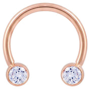 14k rose gold circular barbell with large bezel-set CZ ends, 12G front view on white background