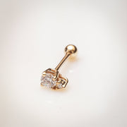 14k yellow gold birthstone cartilage stud with CZ, lifestyle shot on warm surface