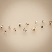 Assorted 14k gold cartilage stud earring styles laid out flat showing variety of designs