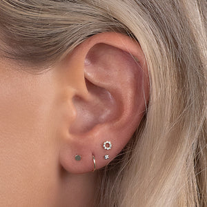 Diamond halo flat back earring shown in a curated earlobe piercing stack with mixed gold studs