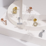 14K gold CZ halo flat back earring displayed among assorted CZ labret styles on white surface