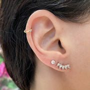White sapphire pear crescent climber earring worn on pierced lobe in earring party stack