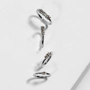 Four 14K white gold two-diamond seam ring hoops in multiple sizes arranged on white marble surface