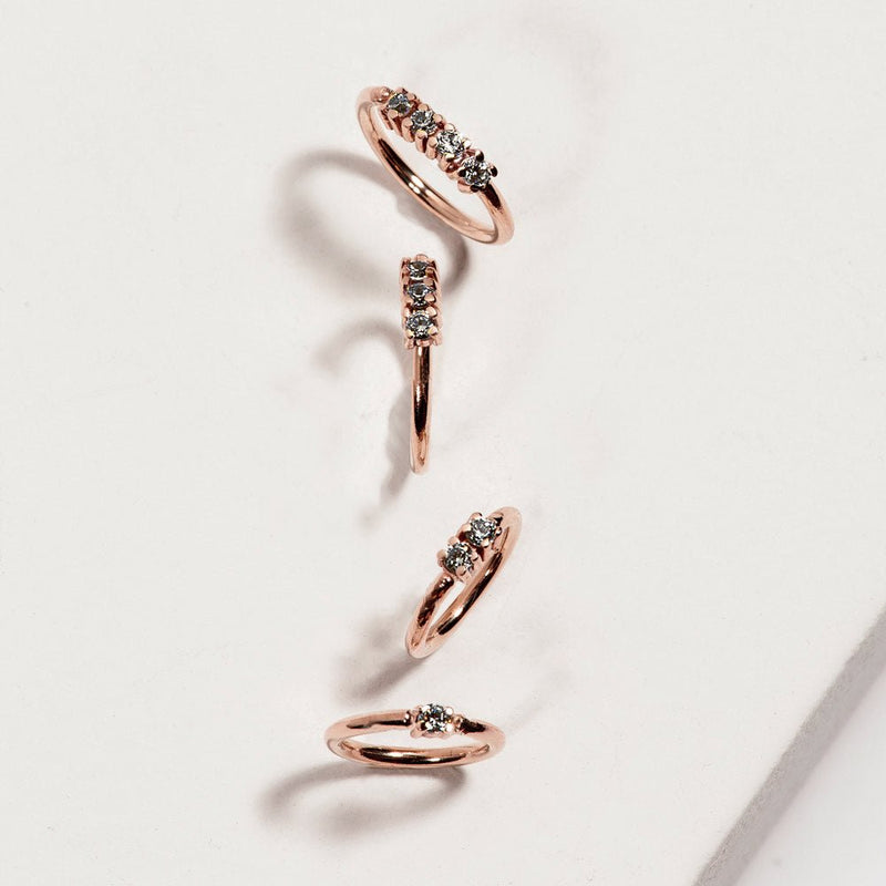 14K rose gold four-diamond seam rings in four sizes displayed on white marble surface