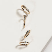 Multiple 14K yellow gold diamond side-set seam rings in various sizes arranged on white surface