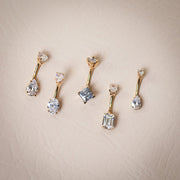 14k yellow gold belly ring collection showing five CZ cuts including emerald, oval, princess, and pear styles