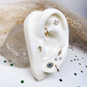 14k gold diamond lightning bolt stud on white ear display with curated multi-piercing styling