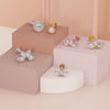 White and yellow gold 2mm diamond milgrain flat back studs styled on tiered pedestals alongside other diamond labrets