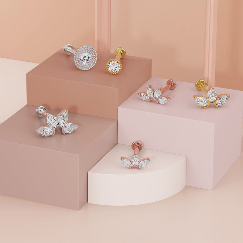 White and yellow gold 2mm diamond milgrain flat back studs styled on tiered pedestals alongside other diamond labrets
