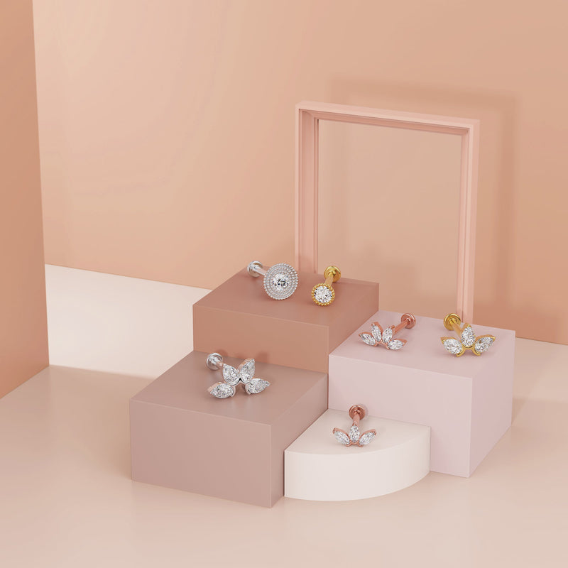 White gold milgrain CZ flat back stud styled alongside gold and rose gold CZ labret studs on pink risers