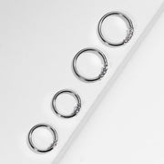 Four 14K white gold diamond seamless hoops in graduating sizes arranged along white ledge