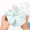 Hands polishing a gold ring with a soft cloth, jewelry rings blurred in background, FreshTrends Restore Service