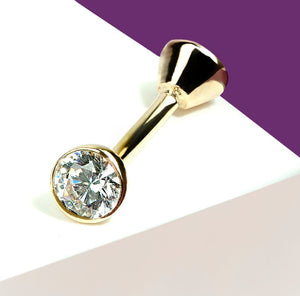Angled view of 14k gold bezel-set diamond curved barbell showing brilliant-cut stone sparkle