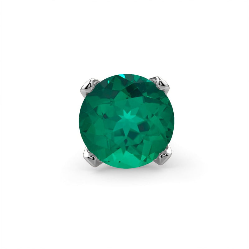Close-up of genuine emerald in four-prong white gold setting, front-facing stone detail view