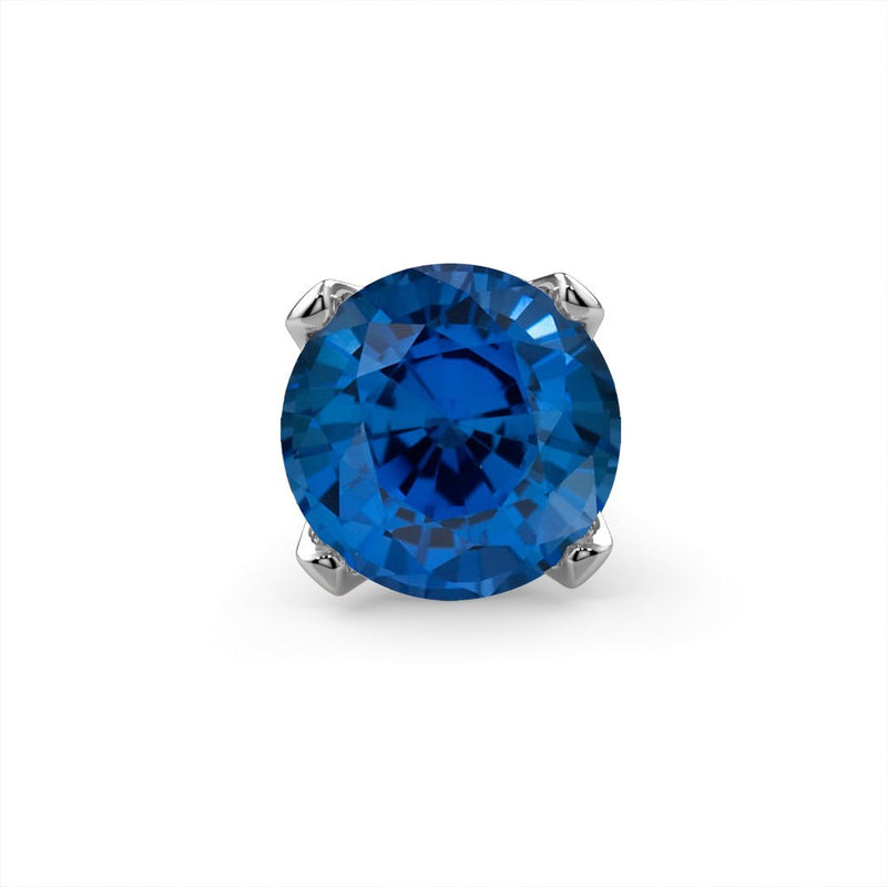 Close-up of genuine blue sapphire in four-prong setting, front view showing deep blue faceted stone