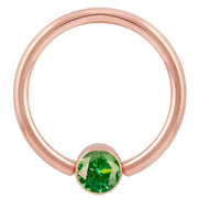 14k rose gold fixed bead ring with emerald green CZ bezel, larger gauge front view