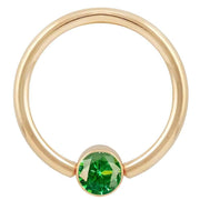 14k yellow gold fixed bead ring with emerald green CZ bezel setting, large gauge front view