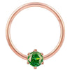 Close-up front view of 14k rose gold fixed bead ring with vivid green CZ prong detail