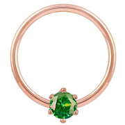 Close-up front view of 14k rose gold fixed bead ring with vivid green CZ prong detail