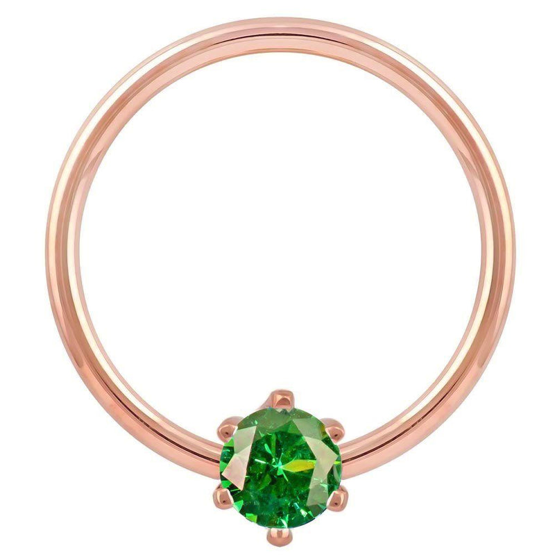 Close-up front view of 14k rose gold fixed bead ring with vivid green CZ prong detail