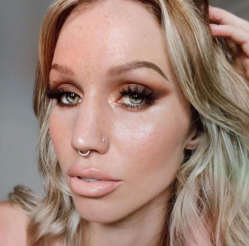 Diamond pave gold clicker ring worn as a septum piercing on a model, showing fit and scale