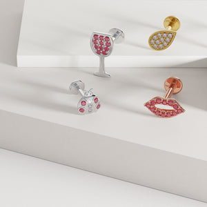 14k yellow gold diamond teardrop flat back earring styled with other gold pavé labret studs on white surface
