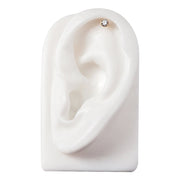 14k gold bezel CZ cartilage stud shown in helix piercing on white ear display, top-down view