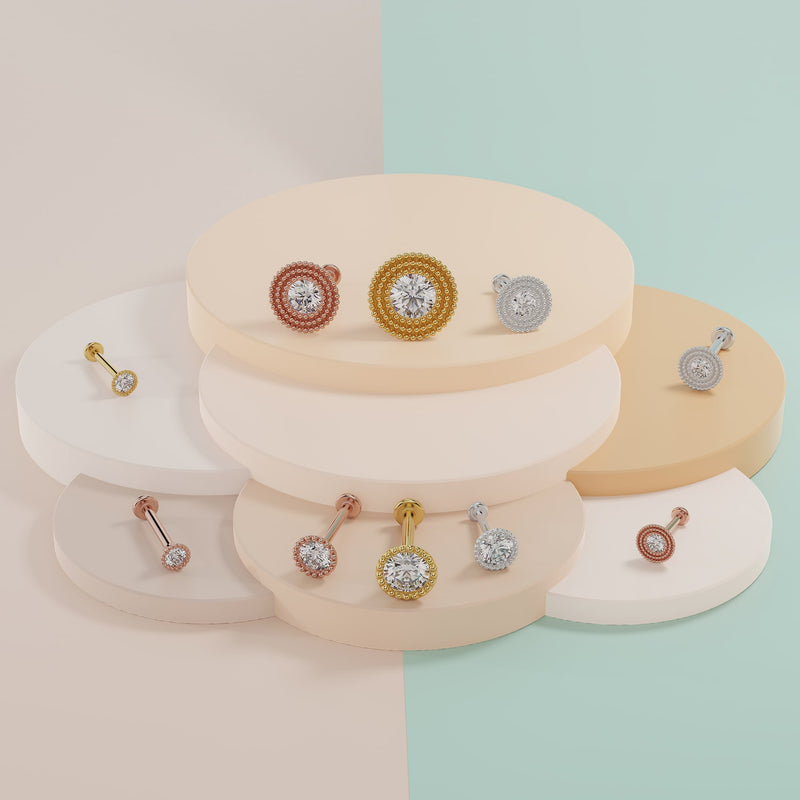 Diamond milgrain flat back studs in yellow gold, rose gold, and white gold displayed on tiered risers