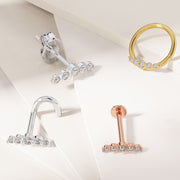 14K white and rose gold CZ climber flat backs alongside yellow gold CZ ring, all three metal colors