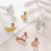 Assorted nature-themed 14K gold flat back earrings in yellow, rose gold, and white gold displayed on marble