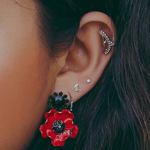Gold crescent moon flat back earring worn in helix piercing, styled with mixed ear stack on model