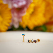 14k gold 3mm cabochon flat back labrets on surface with floral background showing pearl among stone options