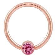 14k rose gold fixed bead ring with bright pink round-cut CZ in bezel setting, front view