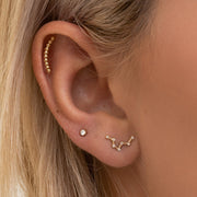 14k yellow gold diamond bezel stud in lobe piercing styled with constellation earring and cartilage bar