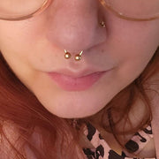14k gold circular barbell shown in a septum piercing, close-up fit view on model