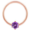 Close-up of 14k rose gold captive ring highlighting purple CZ prong setting and polished band