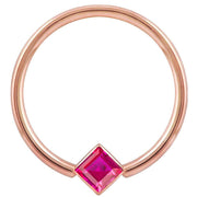 14k rose gold fixed bead ring with red princess-cut CZ in corner-mount bezel, front view