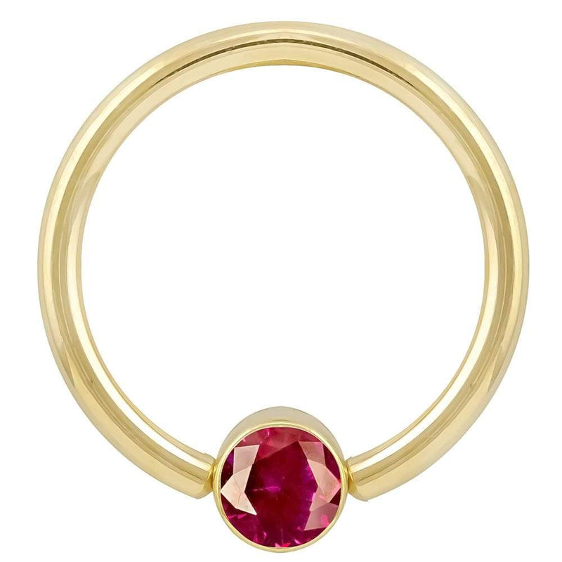14k yellow gold fixed bead ring with red CZ bezel setting, angled front view showing stone detail