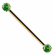 14k yellow gold industrial barbell with green CZ prong-set ends, front view on white background