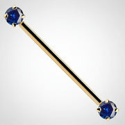 14k yellow gold industrial barbell with dual blue round CZ gems in prong settings, front view