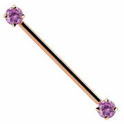 14k rose gold industrial barbell with pink CZ ends, prong-set round-cut gems, front view