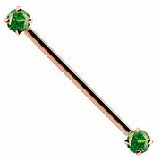 14k rose gold industrial barbell with green round CZ gems at each end, front view