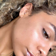 Two-diamond side-set seam ring hoop worn as a cartilage piercing, lifestyle shot on model