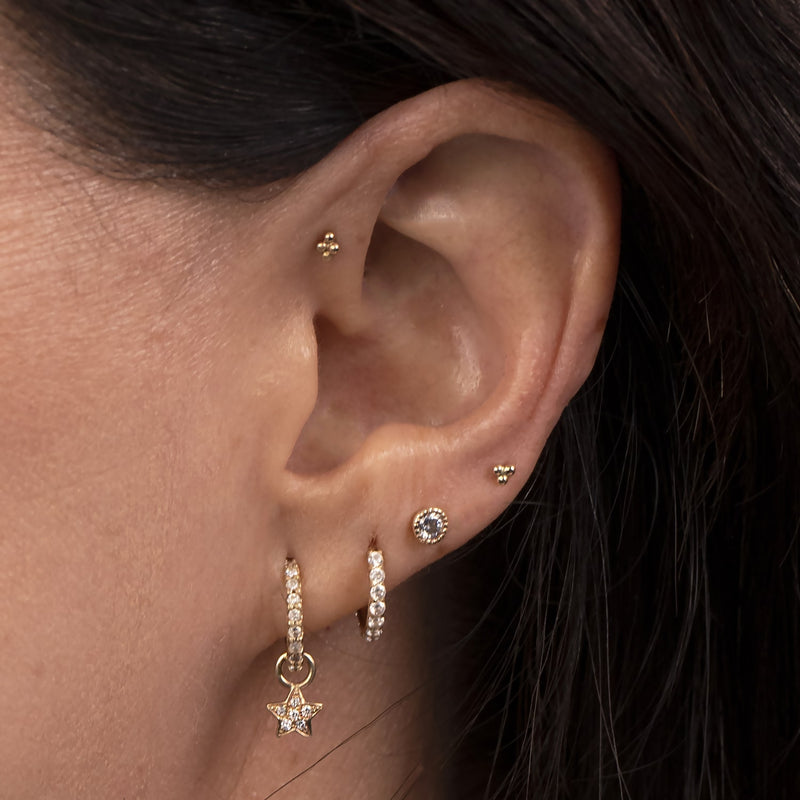 14K gold trinity bead cartilage stud shown in helix piercing on model's ear