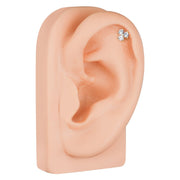 Triple CZ 14k gold cartilage stud shown in upper helix piercing on mannequin ear for placement reference